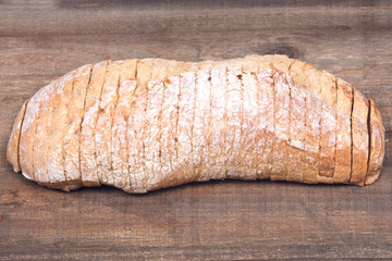 Sliced crusty ciabatta organic italian bread on wooden vintage tray