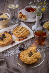 Breakfast for two, lemon tarte and tea on wooden table