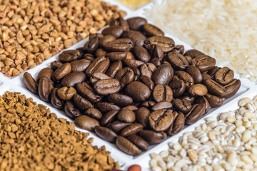 Roasted coffee beans close-up in set of groceries. Food product background with limited depth of field.
