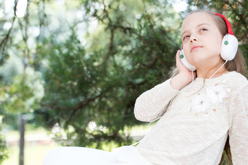 pretty little girl enjoying music using headphones