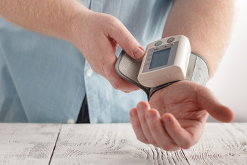 man over fifty measures on his wrist blood pressure