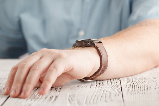 Men Wearing A Black Watch With Black Leather Strap Over A White Background