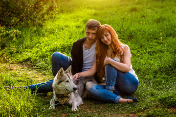 Fototapeta premium A young couple walking a dog in the park