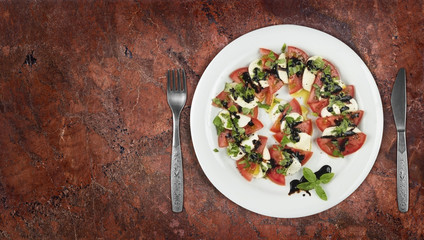 Caprese salad dish on granite countertop with copyspace on side.Top view