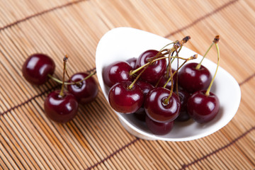 Ripe sweet cherry in a bowl on a napkin