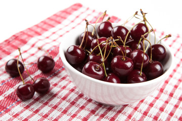 Ripe sweet cherry in a bowl on a napkin