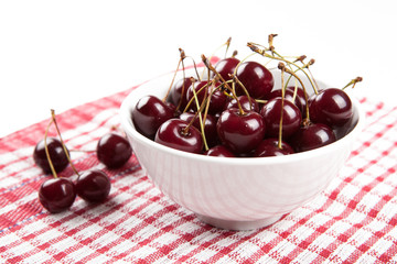 Ripe sweet cherry in a bowl on a napkin