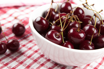 Ripe sweet cherry in a bowl on a napkin