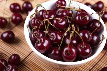 Ripe sweet cherry in a bowl on a napkin