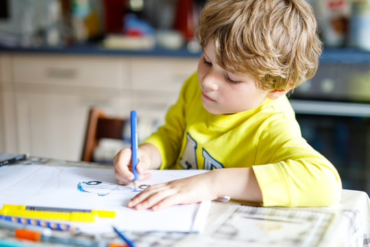 Adorable preschool kid boy painting with colorful pencils police car