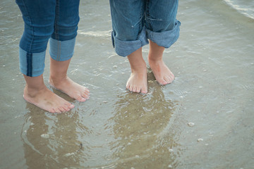 Kids. Legs of two small friends in the ocean water