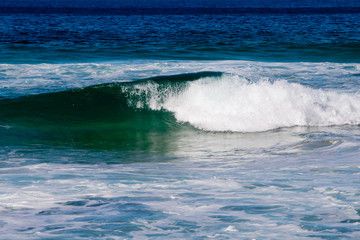 Curling incoming greens and blues in wave - Australia