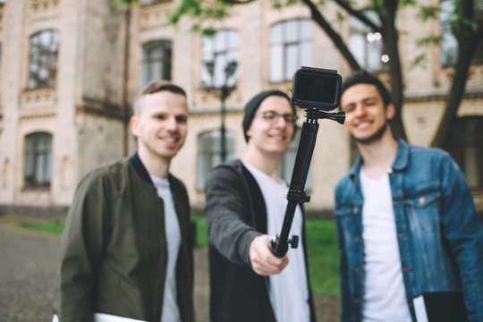 Successful happy students standing near campus or university outside