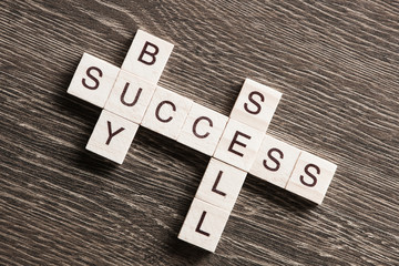 Buy sell success concepts collected in crossword on wooden table