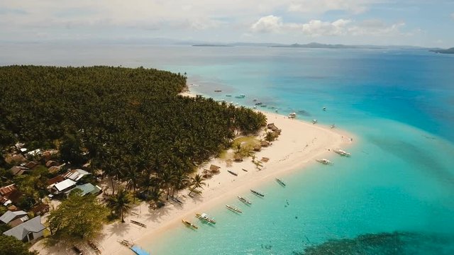 Aerial view of beautiful tropical island Daco with white sand beach. View of a nice tropical beach from the air. Beautiful sky, sea, resort. Seascape: Ocean and beautiful beach paradise. Philippines