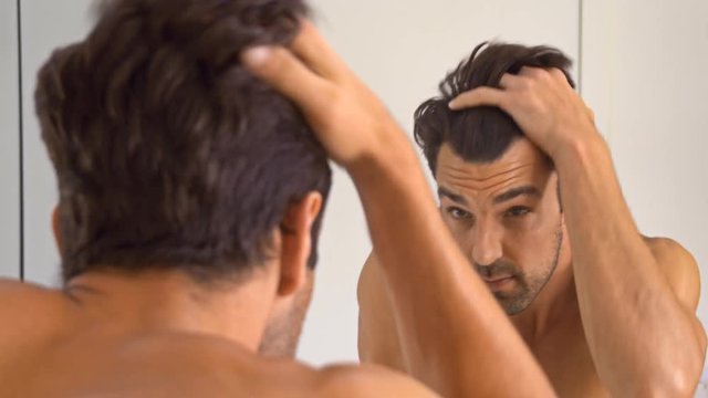 Tired man who has just woken up gets ready for his morning shower.