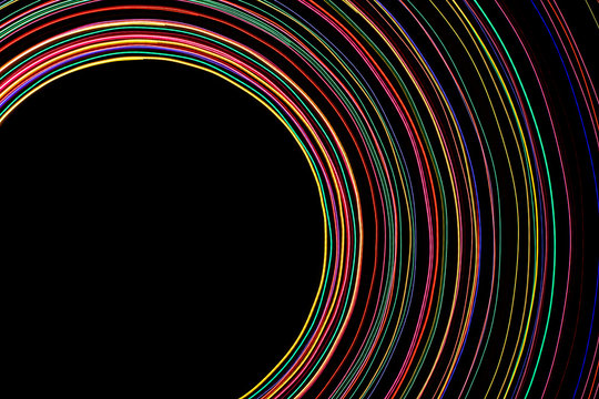 Black empty copy space inside neon color rotating lines background.