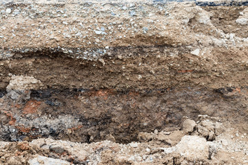 Rocky soil background under paved road.