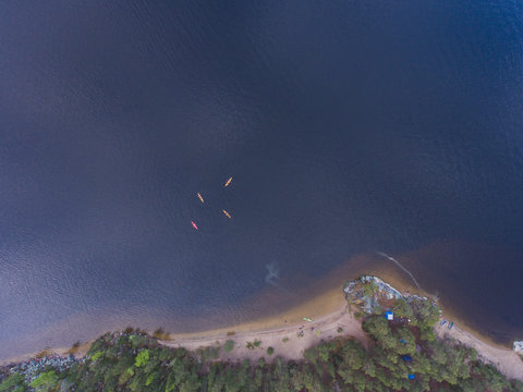 A group of kayakers in the lake skerries on the with colorful canoe kayak boat, shot from drone