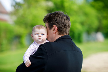 Happy proud young father with newborn baby daughter, family portrait togehter