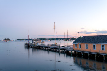 Fototapeta premium Boathouse and dock in the calm and beautiful Boothbay Harbor at dusk