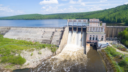 Spillway on old hydroelectric power station in sunny day aerial view