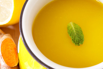 a cup of Turmeric Tea with lemon and ginger , Benefits for reduce Inflammation , Liver Detox and Cleanser healthy herb drink concept