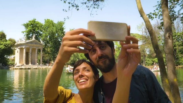 Young Couple Taking Selfie by a Pond in a Park in Rome