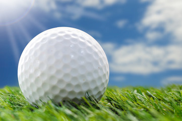 golf ball on grass with blue sky