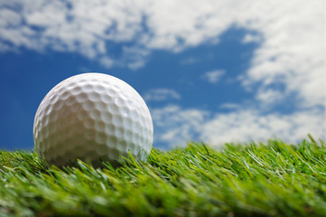 golf ball on grass with blue sky