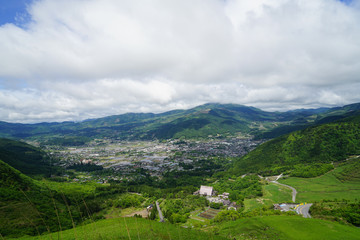 Greenery mountain landscape panorama and town view with white cloudy sky