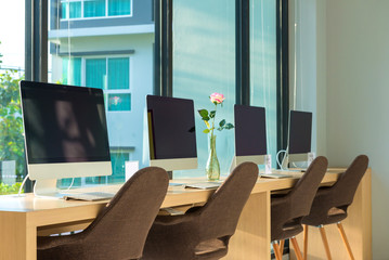computer desktop with keyboard, diary and other accessories on table in cafe