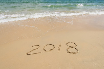 2018 written in sand write on tropical beach