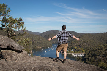 Fototapeta premium Man overlooking valley with arms wide