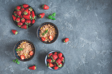 Obraz na płótnie Canvas Breakfast with muesli, fresh strawberry on black background. Healthy food concept. Flat lay, top view