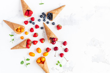 Fruit background. Fresh fruits and berries in waffle cones. Summer concept. Flat lay, top view, copy space