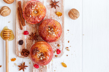 Red baked apples with cinnamon, walnuts and honey. Autumn or winter dessert.