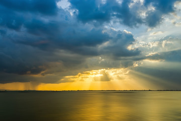 Sunbeam behind cloud over the lake.