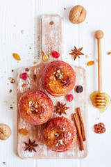 Red baked apples with cinnamon, walnuts and honey. Autumn or winter dessert.