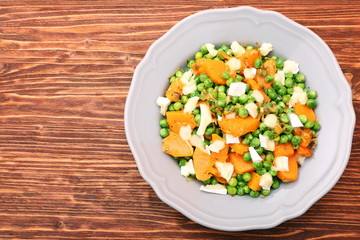 Warm salad with roasted pumpkin, peas and cheese brie