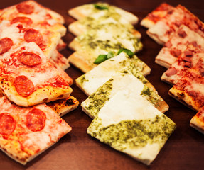 Pizza pieces to go on a stall in pizzeria, may use as background,  Traditional Italian Focaccia with tomatoes, black olives and cheese