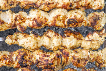 Shish kebab close-up. Slices of meat in marinade preparing on fire
