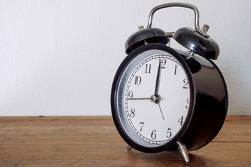 Black alarm clock on wood table