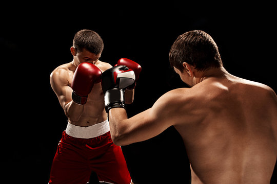 Two professional boxer boxing on black background,