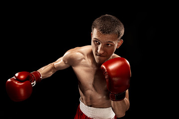 Fototapeta na wymiar Male boxer boxing with dramatic edgy lighting in a dark studio