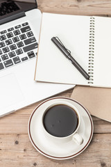 office working desk top view with laptop, notepad and coffee