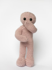 Häkelmännchen mit Hand vor dem Mund