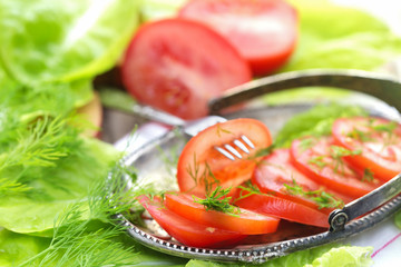 The cut tomatoes with lettuce leaves and fennel