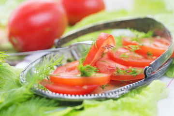 The cut tomatoes with lettuce leaves and fennel