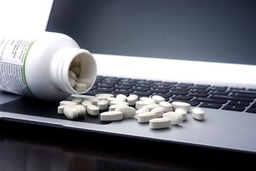 Medicine tablets on a laptop computer.